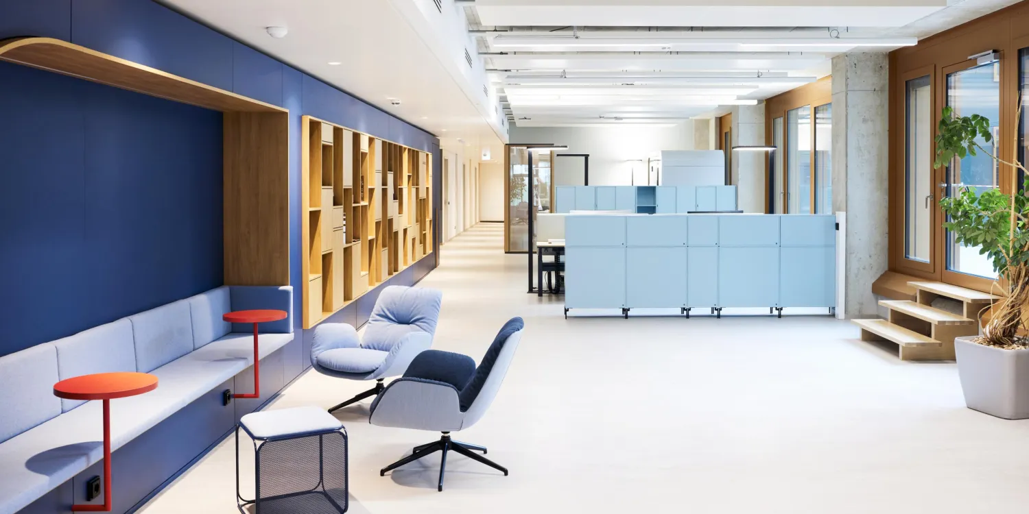 NanoTemper – Modernes Open-Space-Büro mit flexiblen Arbeitsbereichen, Lounge-Zone und farbigen Akzenten.